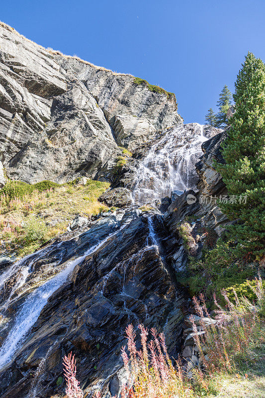 意大利奥斯塔的大帕拉迪索国家公园里，利拉兹瀑布(Cascate di Lillaz)冲刷着花岗岩喀斯特岩石急流(垂直拍摄)